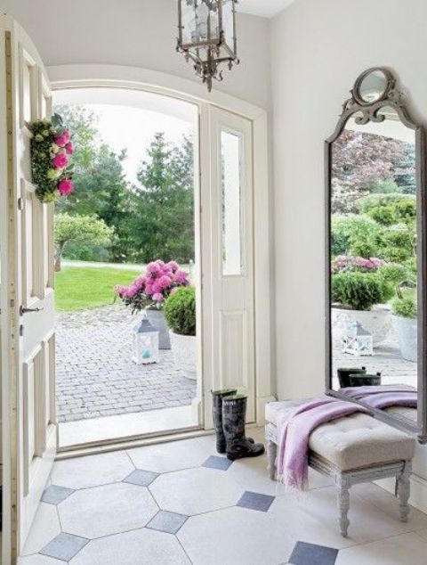 a large mirror in a vintage grey frame with chic detailing for a country chic entryway