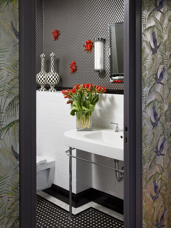 The bathroom is done in black and white with catchy patterns and red touches