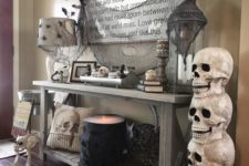 12 a rustic console with black bats and spiders, black spiderweb and a lit up cauldron plus skulls