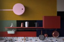 13 a dark blue kitchen with a terrazzo countertopp, brass fixtures and postal red shelf plus green and yellow color blocking