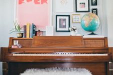 13 a gallery wall with signs, photos, artworks in various colors over the piano for a cool and chic look