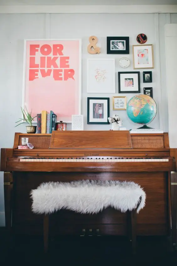a gallery wall with signs, photos, artworks in various colors over the piano for a cool and chic look