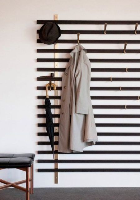 A simple wall mounted hanger of wooden slabs and hooks attached where necessary   you won't need more for a small space