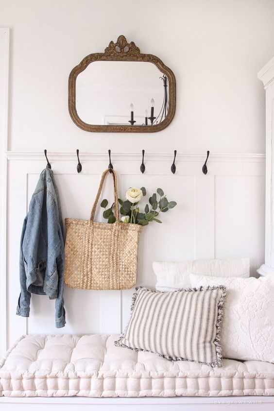 a small mirror in a vintage metallic frame is ideal for a cozy cottage entryway