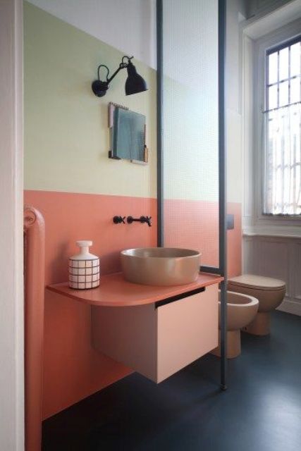 A light yellow and coral plus matching pinkish fixtures for the powder room to give it a mid century modenr feel