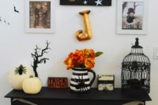 14 a small console with faux pumpkins, a cage, letters, a psider and some artworks