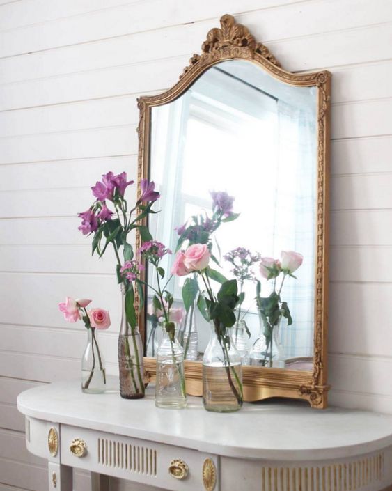 an antique white and gold console and a refined mirror in a vintage gold frame for a chic feel