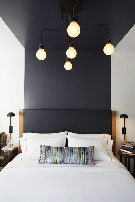 For making your space ultra modern, just go for color blocking, like here a black headboard flowing into the wall and ceiling over the bed