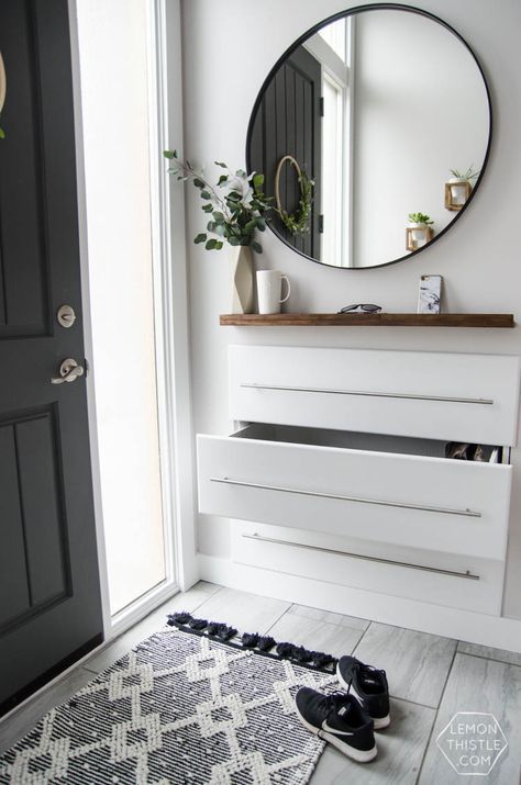 a modern entryway floating console with neutral pulls and a wooden shelf over it