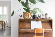 15 a piano with a chair and a display of cacti, succulents and other greenery – make your piano double as a plant stand