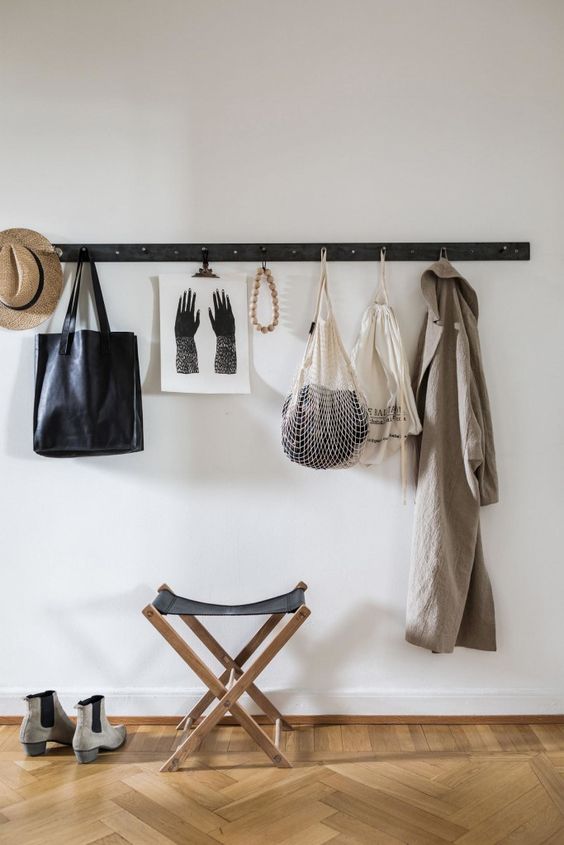 a simple wooden strip with metal hooks is a perfect fit for a minimalist space and an easy DIY project