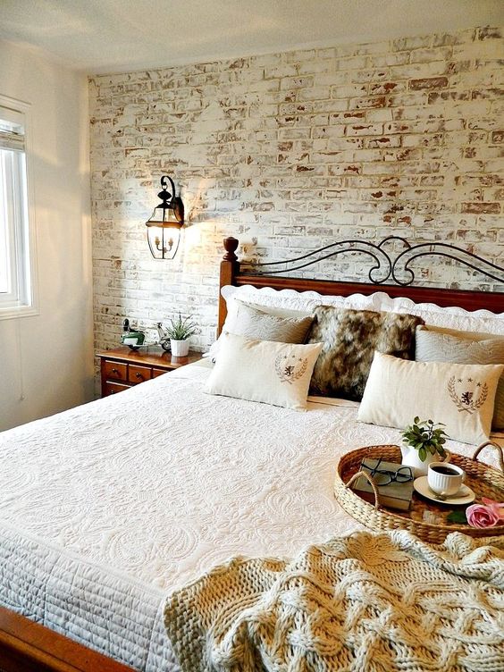 A whitewashed red brick headboard wall is an interesting solution to add color to the space