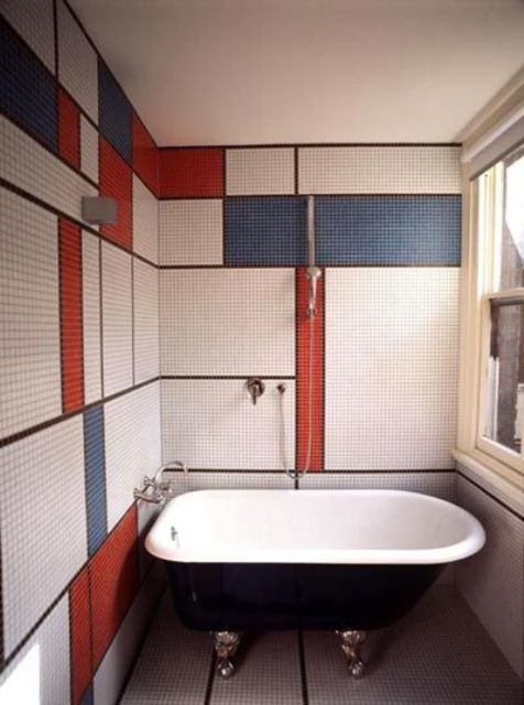 bathroom walls clad with tiles with a color block effect, in white, blue and red make the space stand out