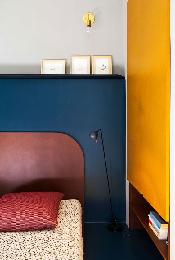 stylish color blocking with a navy headboard wall and a bright yellow wall on the right