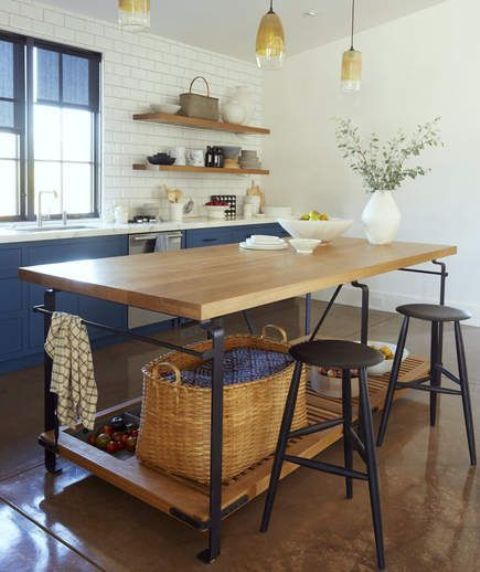 a chic kitchen with an industrial kitchen island of wood and metal plus storage space and tall stools