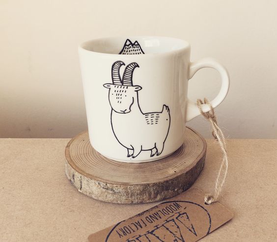 a fun and quirky goat mug on a wood slice coaster