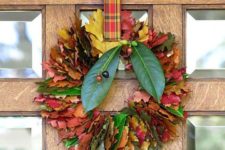 17 a bold and cozy fall leaf wreath with colorful foliage, berries and a plaid ribbon to hang it