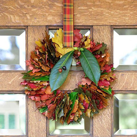 A bold and cozy fall leaf wreath with colorful foliage, berries and a plaid ribbon to hang it