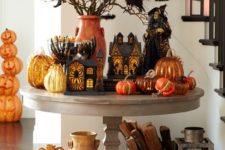 17 a spooky rustic display with lots of pumpkins in bold shades, cardboard houses and lots of birds