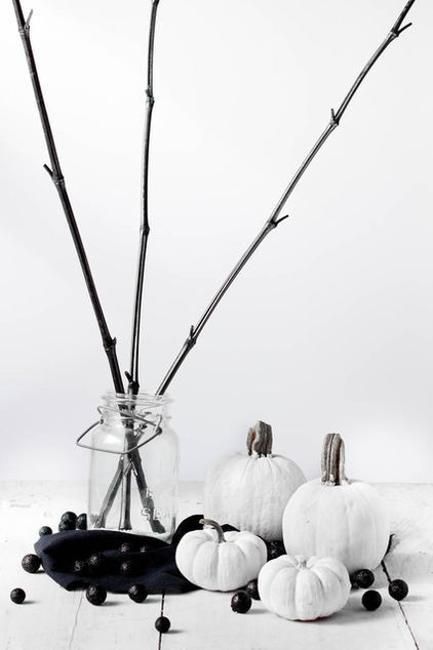 white pumpkins and black beads plus black branches in a clear vase for a stylish minimalist display