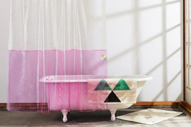 a color block see-through shower curtain and a geometric towel to easily make your space trendier
