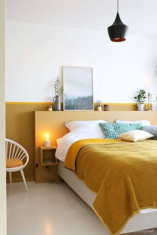 a mustard headboard and wall behind it for a color block effect and a touch of color in the bedroom