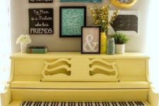 18 a sunny yellow piano and a matching stool, a gallery wall over the piano with various signs and art