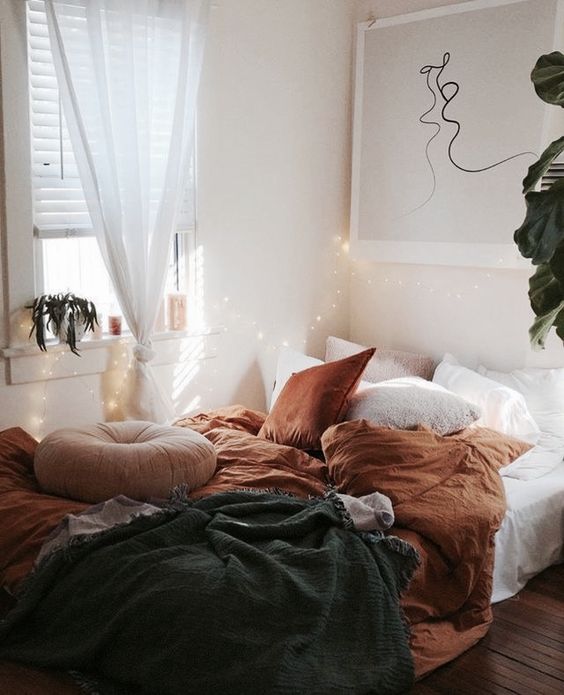 fall-colored bedding in rust color and a dakr grey blanket to subtle embrace the fall