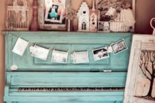 19 a turquoise piano with a photo bunting and a vintage display of various figurines, frames and other items