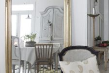 an oversized floor mirror with amazing vintage detailing in gold for a chic and refined entryway