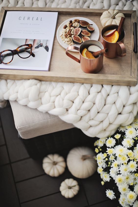 a chunky knit white blanket and copper mugs on a wooden tray are great for fall bedroom decor