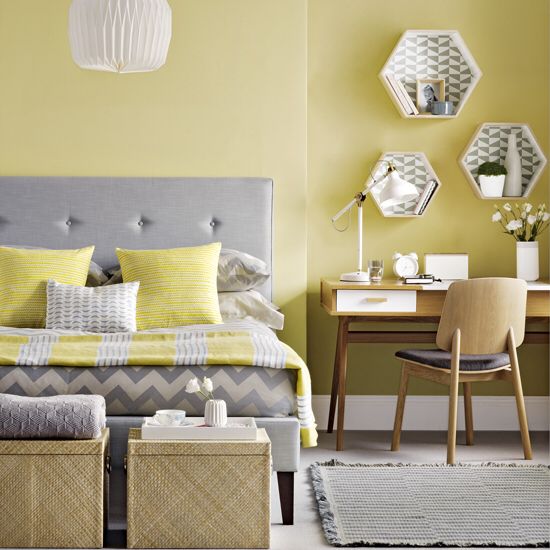 a pale yellow statement wall and matching pillows and a blanket for a colorful touch
