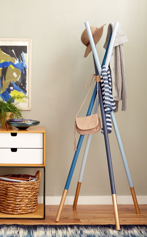a simple and colorful coat rack of several sticks painted in different colors and metallics for a touch of brightness