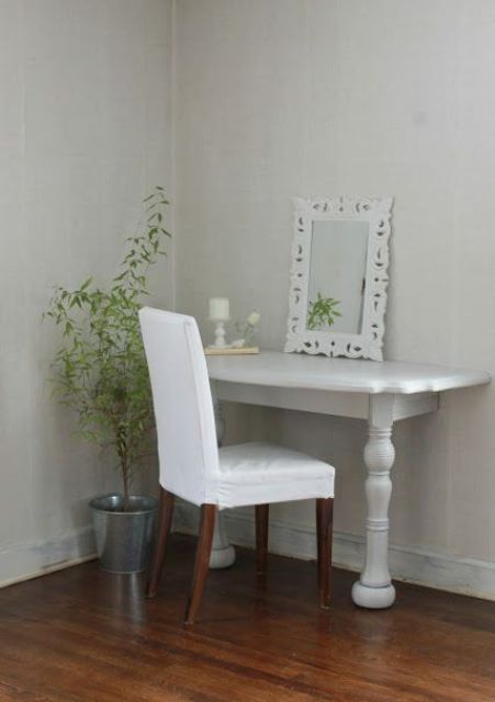 a small makeup nook done in vintage style, with a half cut table and a fabric covered chair