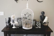 22 a vintage console table with black and white skeletons of various animals, a cage with bats and black calligraphy over the table