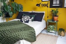 23 a mustard accent wall and touches of dark green and potted plants make up a bold boho space