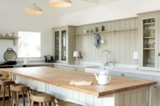 23 a simple and neutral farmhouse space with a large kitchen island and dining table in one with additional storage space