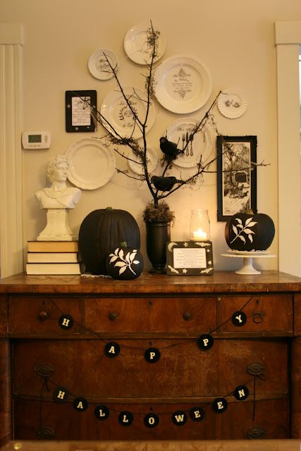 A vintage inspired display with black and white pumpkins, buntings and blackbirds on branches