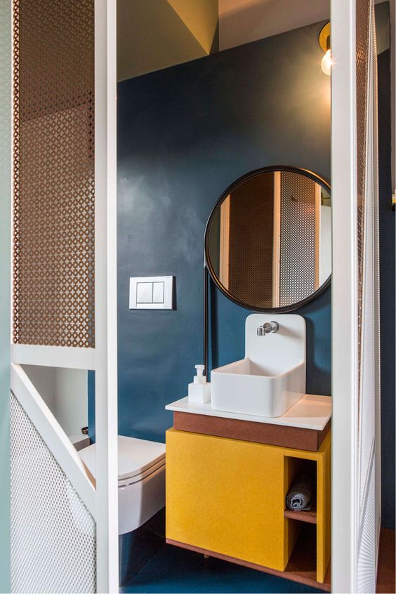 Navy and yellow has always been a cool combo, and here a yellow vanity and a navy wall show it off once again