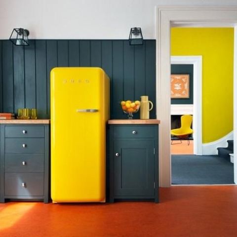 a dark green kitchen is spruced up with a bright yellow fridge for a color block effect