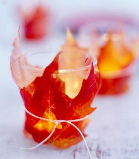 take usual glass candle holders or ready candles and cover them  with fake fall leaves using simple threads