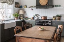 a grey farmhouse kitchen with planked cabinets, a stained vintage dining table and chairs, a planked backsplash