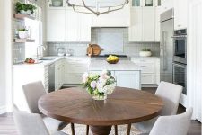 a neutral modern farmhouse kitchen with a pendant lamp, a round table and grey chairs is a very welcoming space