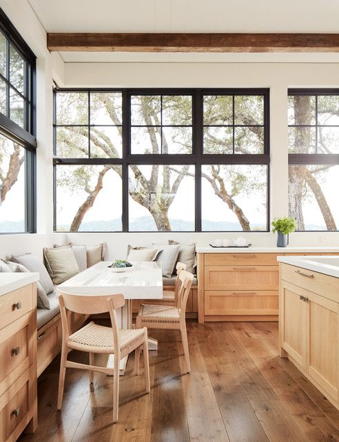 an airy kitchen with a gorgeous view, stained lower cabinets, a cozy eating corner is amazing