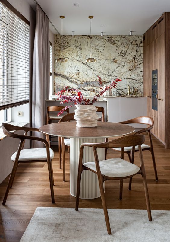 An elegant and refined at in kitchen with a row of lower cabinets and a stained storage unit, a large table and stained chairs and map on the wall