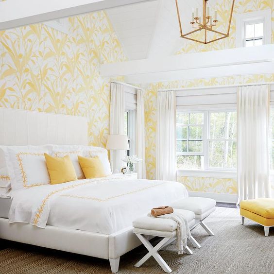 yellow and white wallpaper with botanical prints, yellow pillows and an ottoman for a sun-filled look