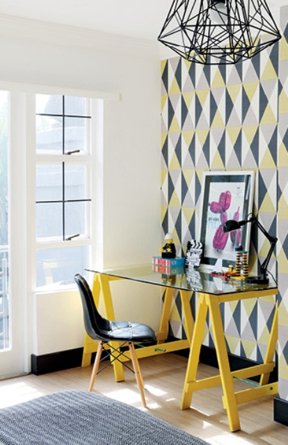 The home office is extremely colorful, with bright wallpaper, artworks and colorful furniture