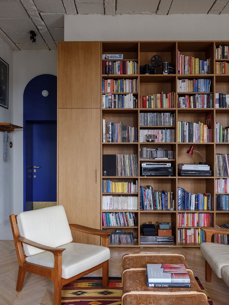 The living room features a large bookshelf, which covers a whole wall