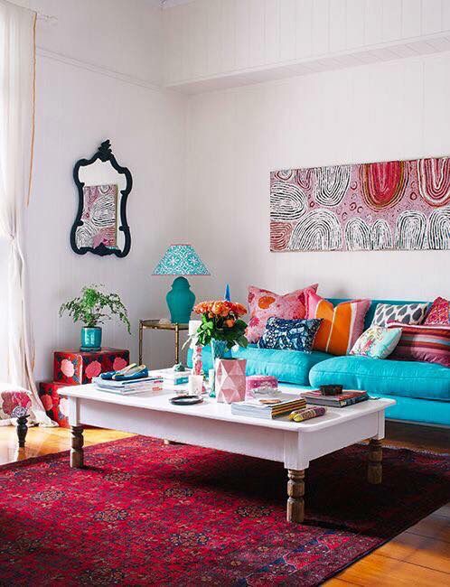 a bold living room with many printed textiles, pillows, artworks and chic furniture