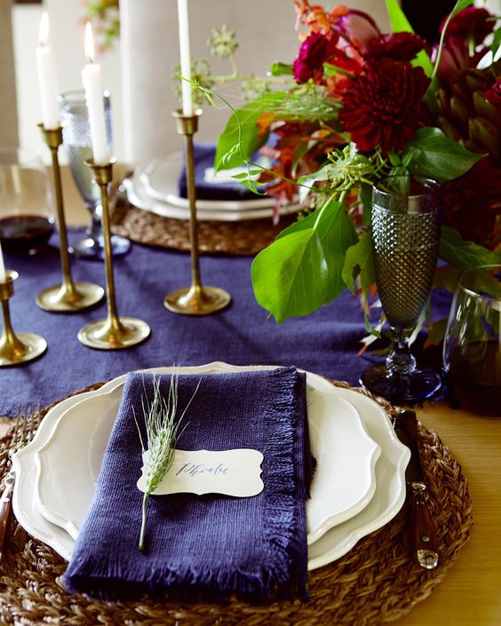a bold violet table runner and napkins plus burgundy blooms make up a super bright tablescape